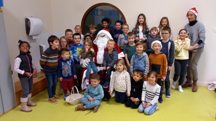 Le p&egrave;re no&euml;l entour&eacute; des enfants